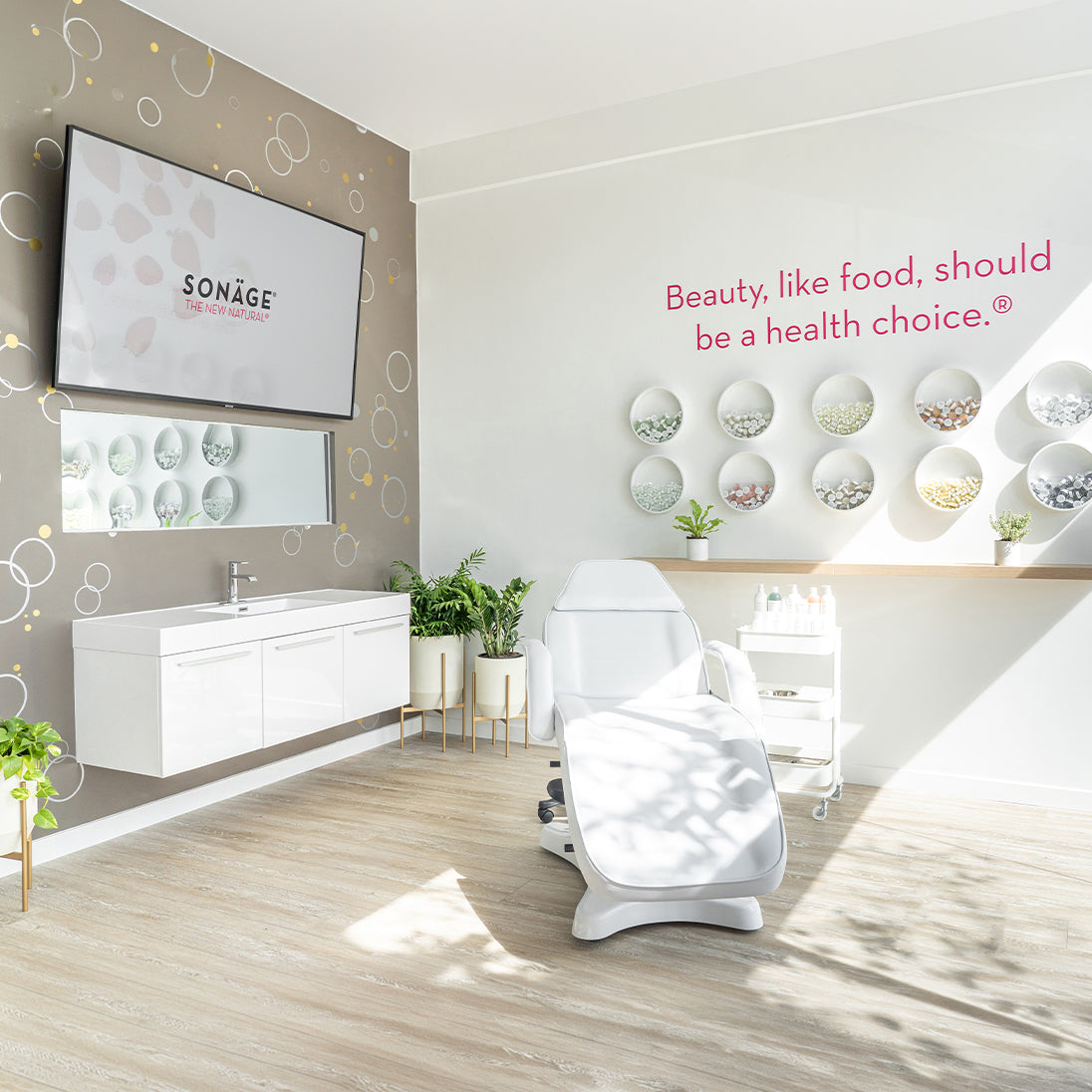 Modern skincare clinic interior with a white treatment chair, Sonage screen, and decorative wall elements.
