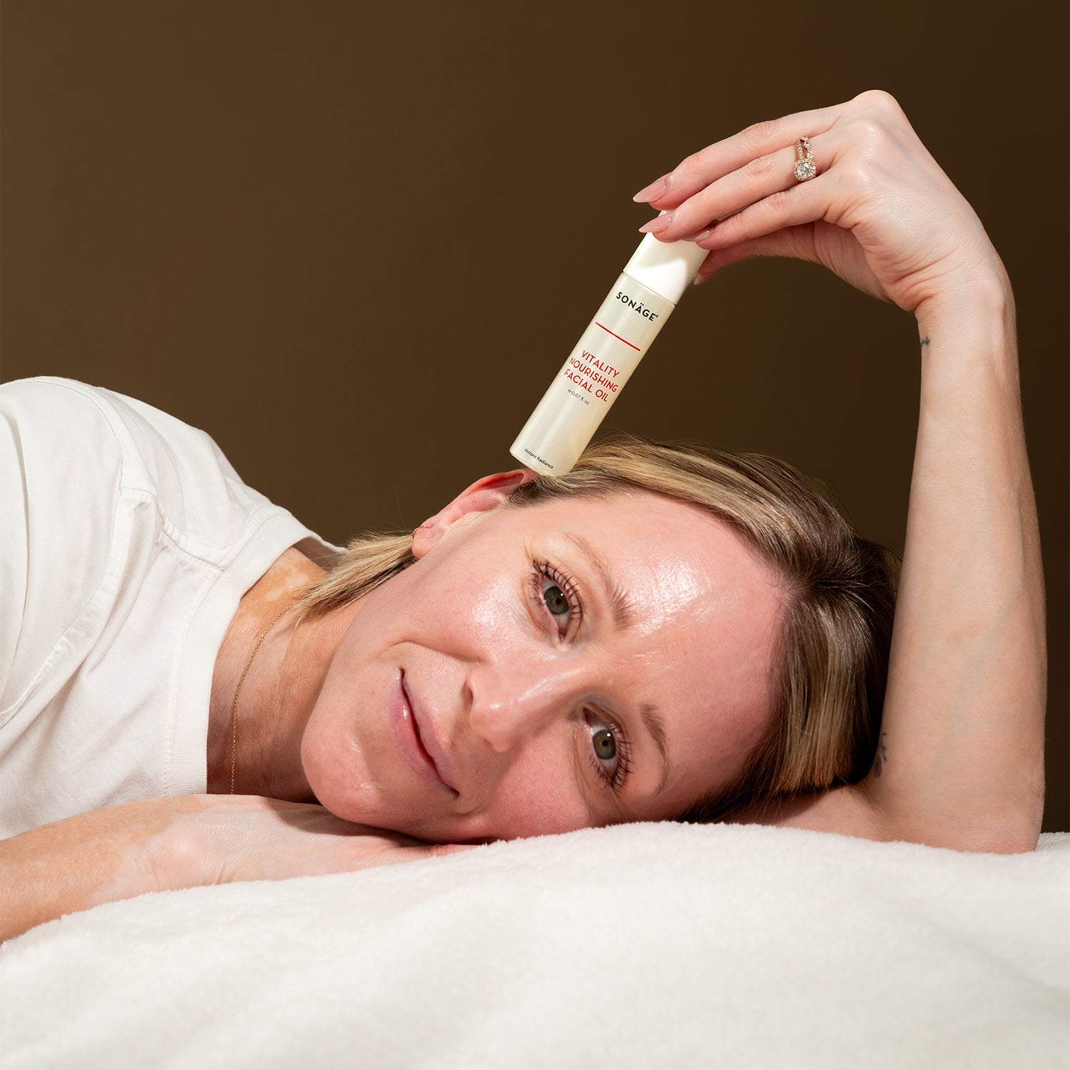 vitality oil balanced on top of a model's face