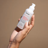 harmony glycopolymer solution held by hand on tan background